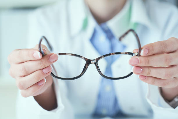 istock Optician giving new glasses to customer for testing and trying. 1194135813