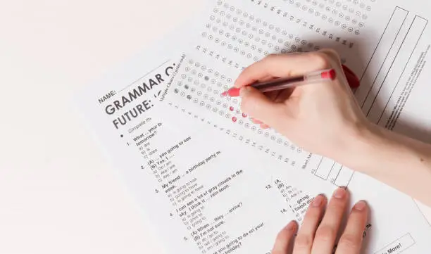 Test of English multiple choice on table.Woman takes an entrance exam.
