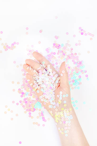 istock Pearl pastel confetti sparkles with woman hand 1194143885