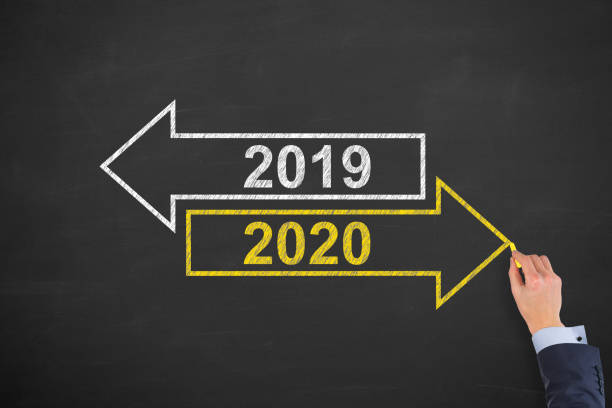 istock Human Hand Drawing Old Year or New Year 2020 on Blackboard Background 1194144081