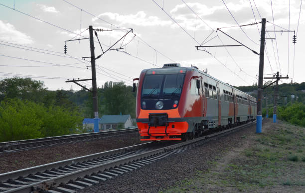 istock Diesel-electric train rides by suburb at dusk 1194144190