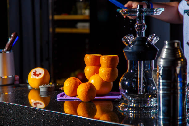 Preparation of hookah. On the bar there is an empty hookah and oranges intended for hookah