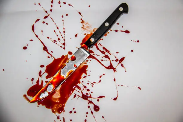 Photo of A blood spatter. The knife with blood.