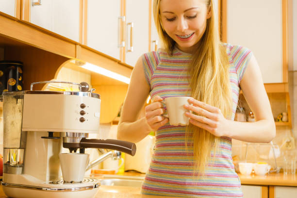 istock Woman in kitchen making coffee from machine 1194147415