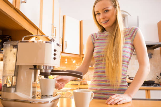istock Woman in kitchen making coffee from machine 1194147743
