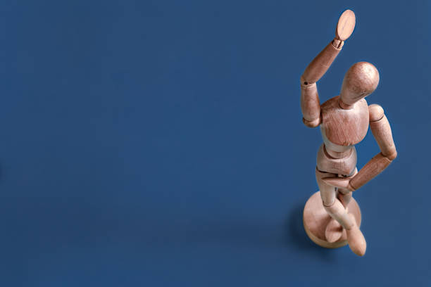 istock The wooden man figurine on a blue background. 1194150886