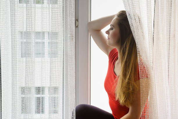 istock Happy woman sitting on windowsill, energizing morning 1194151379