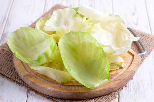 istock Ingredients for cooking cabbage rolls. Cabbage leaves on a cutting board 1194152057