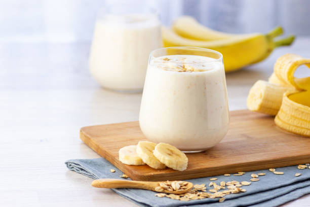Vegan banana and oatmeal smoothie in glass jar on the light background. Vegan banana and oatmeal smoothie in glass jar on the light background. Healthy food. cocktail shaker photos stock pictures, royalty-free photos & images