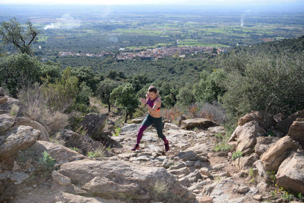 istock Sportswoman runs up a rock-filled mountain trail while doing her daily workout 1194152614