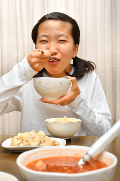 istock Japanese girl enjoys having dinner 1194153627