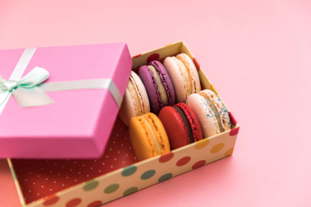 istock Multi-colored macaroon cakes on a pink pastel background in the gift box 1194153731