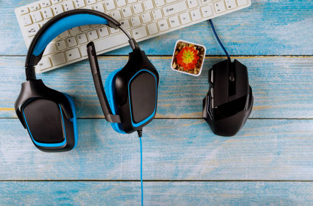 istock Gamepads headphones and keyboard with mouse on old wood blue table 1194154334