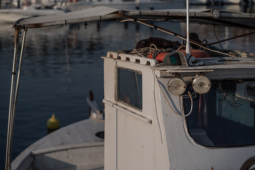 Inshore fishing boat and tackle moored in a harbour at dusk.  Sithonia, Greece.