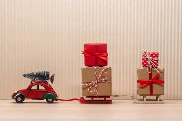 istock christmas red toy car with sledges gift fir-tree 1194154456