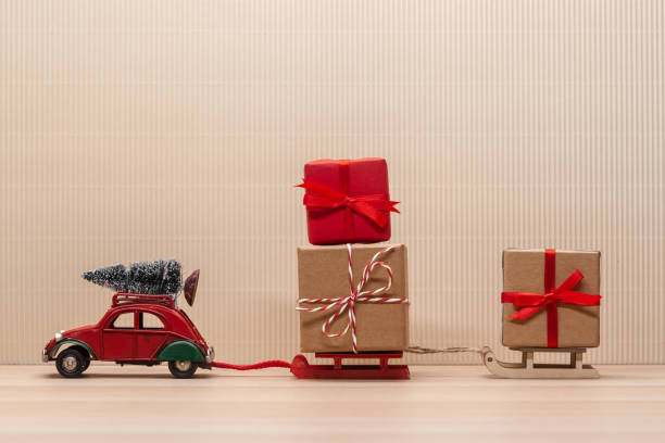 istock christmas red toy car with sledges gift fir-tree 1194154532
