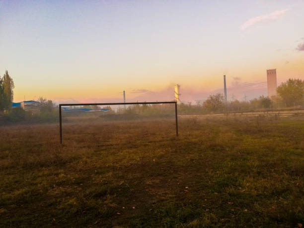 Green football field under blue sky background