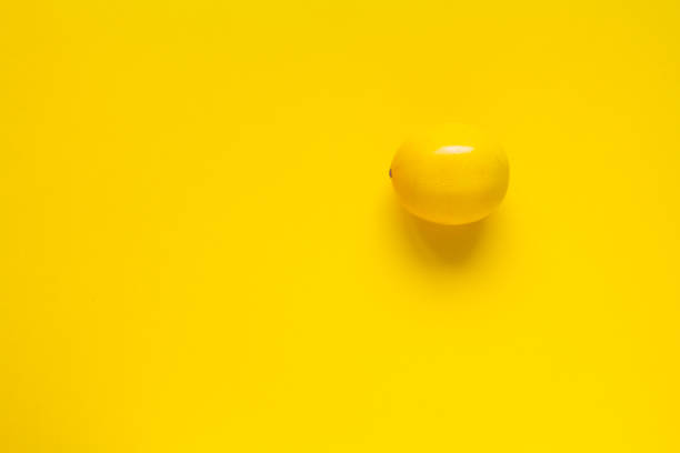 istock Ripe yellow lemon on a yellow surface, minimalistic background or concept 1194157250