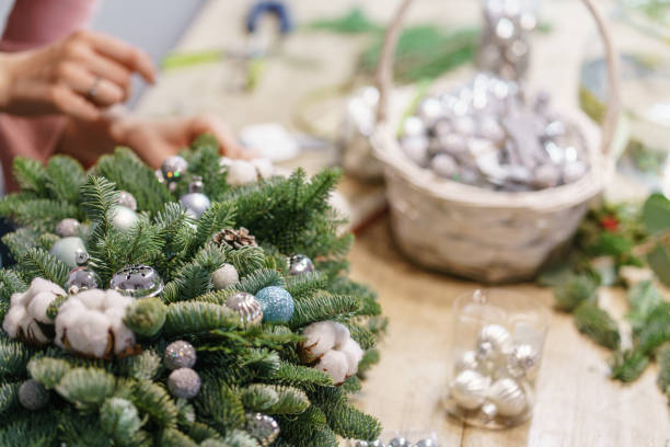istock A woman decorates a Christmas arrangement. Hands close-up. Master class on making decorative ornaments. Christmas decor with their own hands. The new year celebration. Flower shop 1194160445