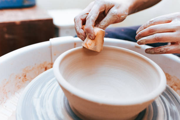 istock Process of creating and formation a white clay ceramic plate. Professional potter is engaged in modeling clay plates. Potter works in a workshop 1194160638