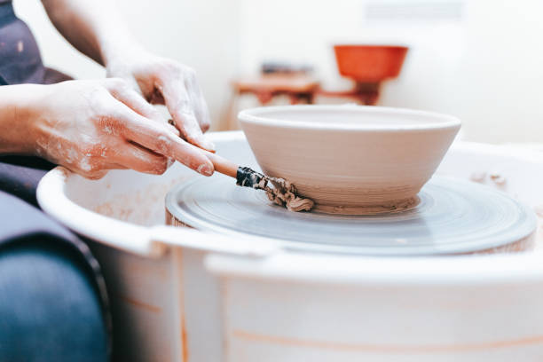 istock Process of creating and formation a white clay ceramic plate. Professional potter is engaged in modeling clay plates. Potter works in a workshop 1194161274