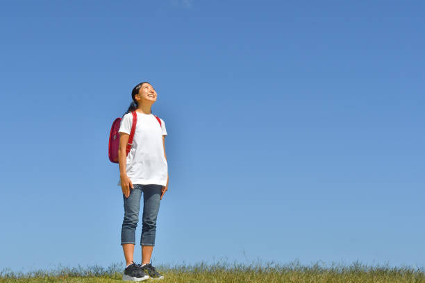 istock Japanese Elementary School Girl Looking up in the Blue Sky 1194161973