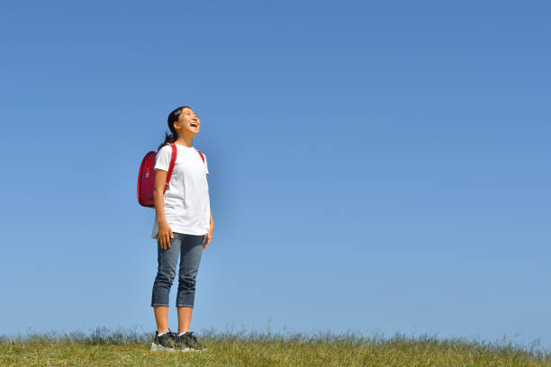 istock Japanese Elementary School Girl Looking up in the Blue Sky 1194161984