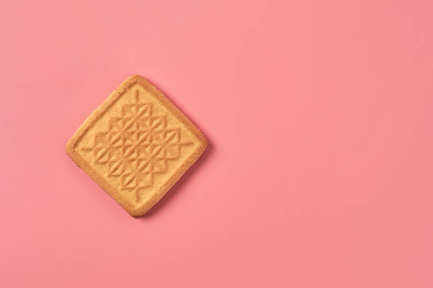istock One whole square cookie lies on pink desk on kitchen. Space for text. Top view 1194163911