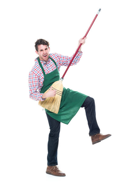 Full length / one person / front view of 20-29 years old adult handsome people caucasian young men / male dancing / exercising wearing gingham / jeans / apron who is smiling / happy / cheerful and holding broom longitud completa / una persona / vista frontal de 20-29 años de edad adulto guapos hombres jóvenes caucásicos / bailar masculino / hacer ejercicio usando gingham / jeans / delantal que es sonriente / feliz / alegre y sosteniendo la escoba