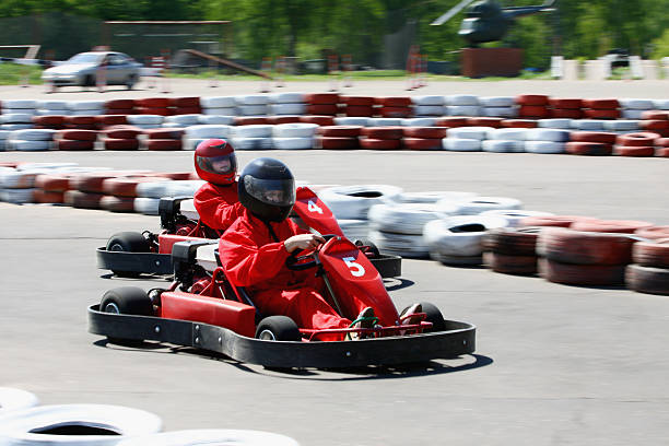 istock Go carts with drivers wearing red racing on a course 119416695