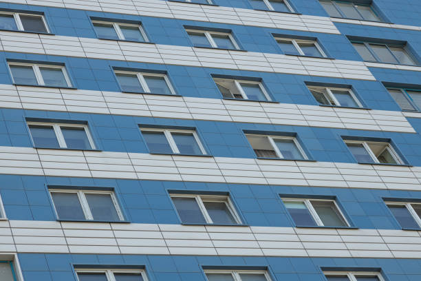 Ground view of apartment building facade with blue and white beige tile surface.