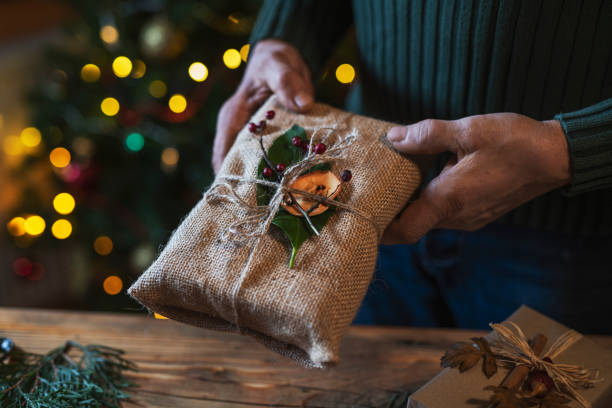 istock Man Holding Organic Christmas Gift. 1194177235