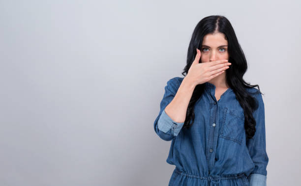 istock Young woman covering her mouth 1194177555