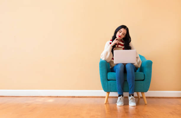 istock Young woman with a laptop computer in a thoughtful pose 1194177579