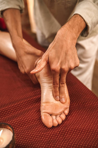 medicina alternativa. terapeuta curando mujer haciendo masaje ayurvédico acupresión presionando en el primer plano del pie - chakra ayurveda recovery herbal medicine fotografías e imágenes de stock