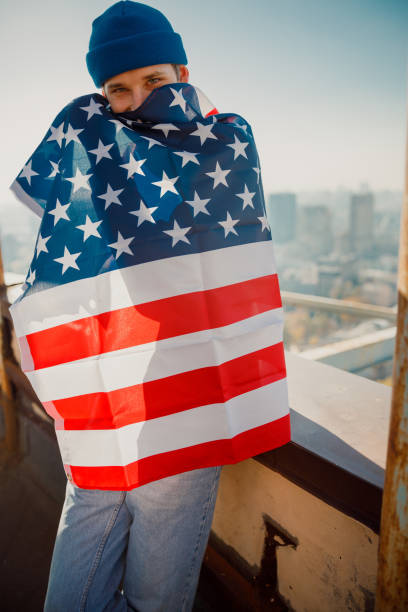 istock Happy young guy standing with flag outdoors 1194179040