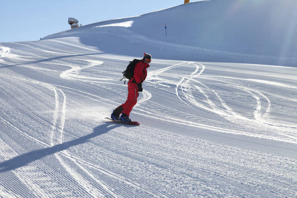 snowboarder in red downhill on snowy ski slope - slalom skiing imagens e fotografias de stock