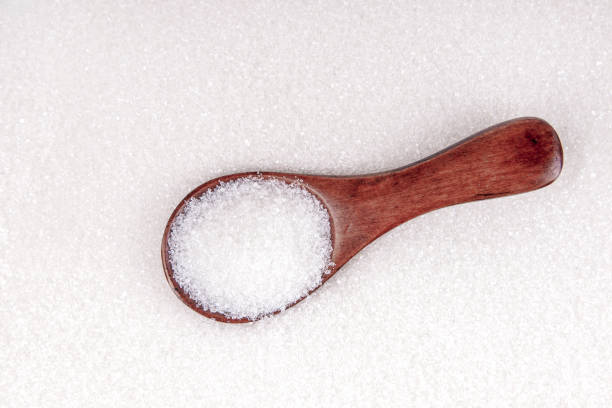 istock White sugar with wooden spoon background top view 1194179303