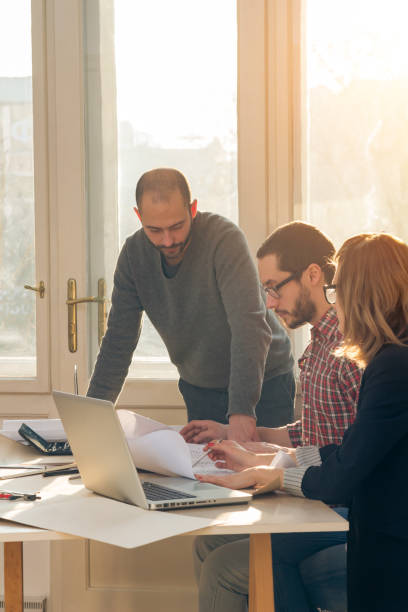 istock Group of young architects in the sunny office. 1194181135