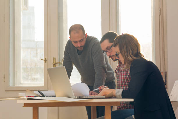 istock Group of young architects in the sunny office. 1194181162