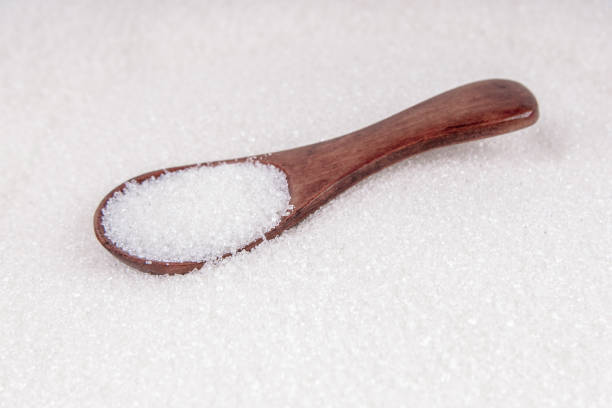 istock Sweet white sugar with wooden spoon background 1194181387