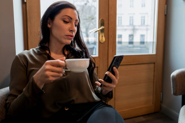 istock Businesswoman using phone in a cafe 1194184068