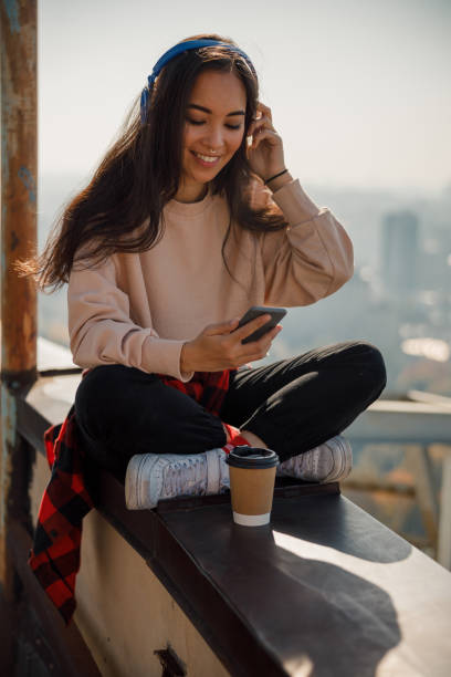 istock Smiling pretty girl is reading messages on roof 1194184858