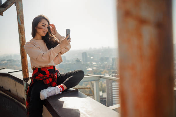 istock Smiling pretty lady making selfie on roof 1194184876