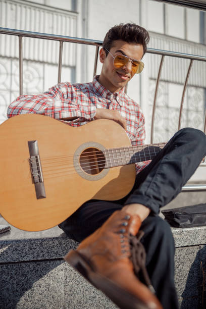 istock Smiling young guy with guitar enjoying sunny day 1194188123