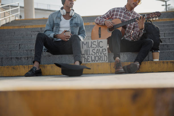 istock Two musicians collecting money in a black hat 1194190617