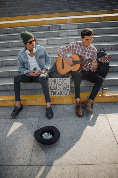 istock Young guy looking at his friend with a guitar 1194190623