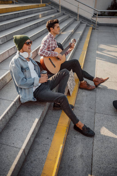 istock Young guy singing and holding coffee in hand 1194190624