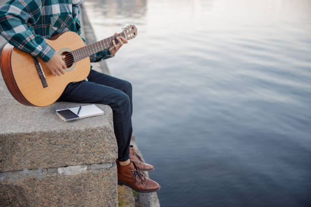 istock Young guitarist resting while playing guitar outdoors 1194190664