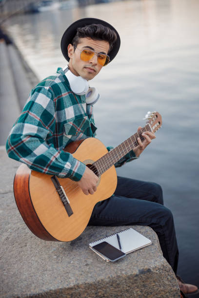 istock Stylish guy with guitar resting near river 1194190670
